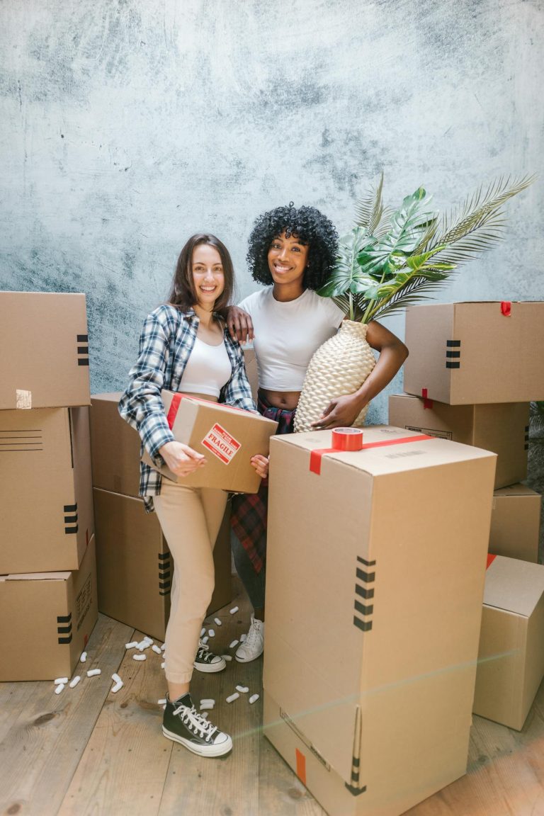 2 Women Standing Beside Brown Cardboard Boxes